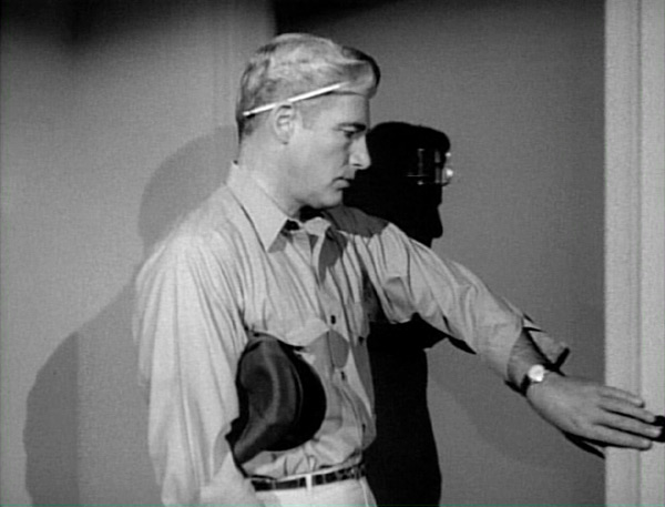 Paul is pressing the doorbell for Irene Collaro's apartment, whom he is visiting in order to locate Ethel Harrison.