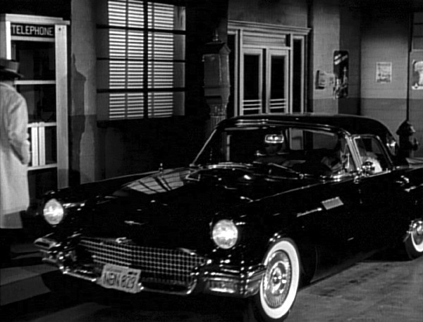 Paul in car with date, pulling up to a telephone booth.